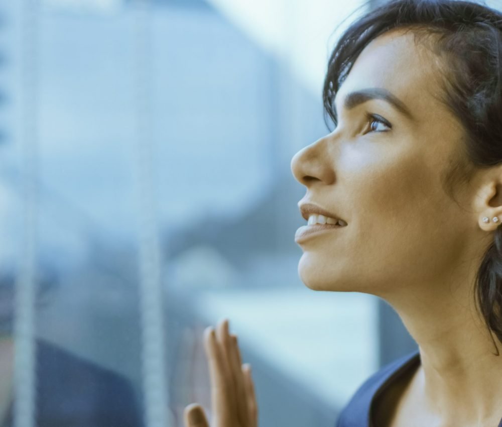 Close-up Portrait of the Beautiful Young Businesswoman Looking Thoughtfully out of Her Office Window. Confident and Attractive Hispanic Woman Thinking about Her Business Project.